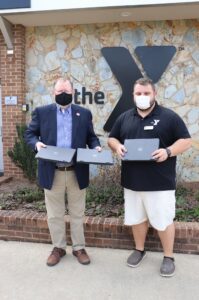 two men holding computers outdoors