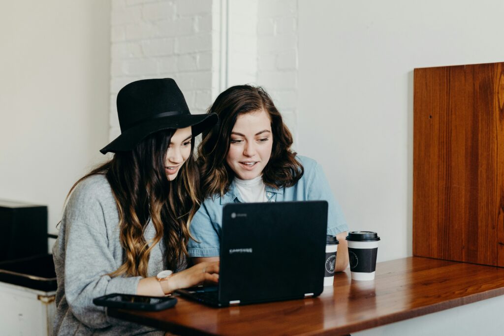 two women working on laptop together
