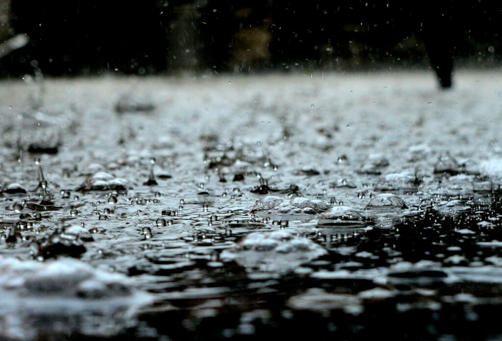 zoomed in on raindrops hitting the ground