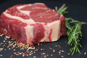 raw steak with peppercorn and herbs