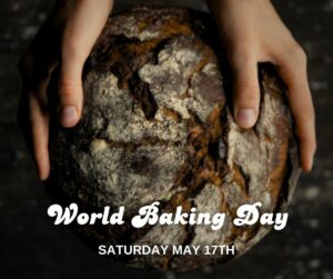two hands holding a loaf of artisan bread with a dark, shadowed background